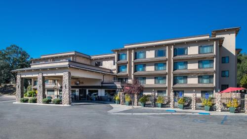 a hotel with a parking lot in front of it at Yosemite Southgate Hotel & Suites in Oakhurst