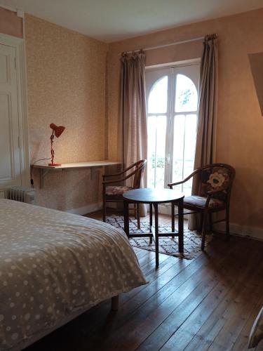 une chambre avec un lit, une table et une fenêtre dans l'établissement chambre chez l'habitant, axe A62, à 20 min d' ouest d'Agen, parking dans la rue gratuit, accès cuisine, convivial, à Port-Sainte-Marie