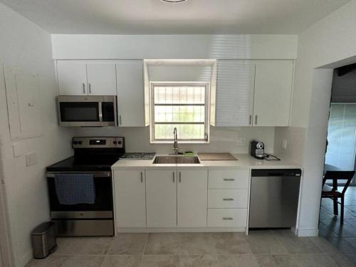 a kitchen with white cabinets and a sink and a window at Luxury Stay- Brickell & Little Havana/ItalianPlaza in Miami