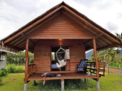 einen Pavillon mit zwei Stühlen auf einer Terrasse in der Unterkunft Namm Natawn in Ko Yao Noi