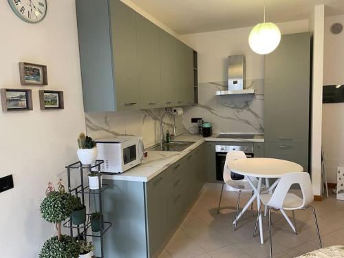 a small kitchen with a table and a microwave at “The green house” Fiera Milano in Pero