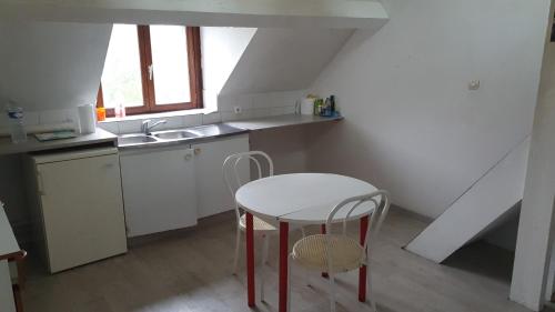 - une cuisine avec une table blanche, une table et un évier dans l'établissement Studio petit pont, à Charleville-Mézières