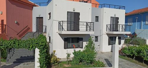 een wit gebouw met trappen en balkons bij Casa Luminosa Guesthouse in Lixouri