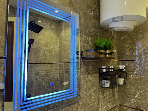 uma casa de banho com chuveiro e vidro azul em Riyadh season studio em Riade