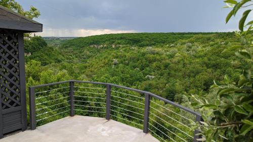 a balcony with a view of a green hillside at Rodynnyi Maietok Family Estate in Kamianets-Podilskyi