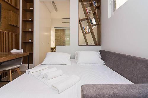 1 dormitorio con 1 cama con toallas en Central modern flat btw Syntagma and Monastiraki, en Atenas