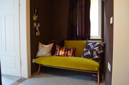 a green couch with pillows on it in a room at Ferienwohnung Winzerloft in Sulzfeld am Main