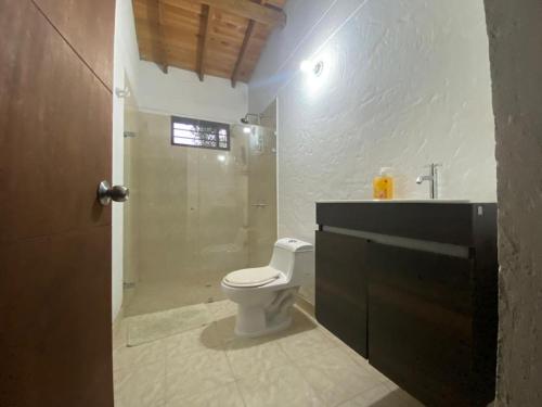 y baño con ducha, aseo y lavamanos. en FINCA VERDI, en Girardota