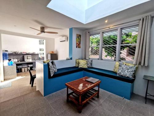 a living room with a blue couch and a window at MAGAYON BLUE HOUSE IN THE HEART OF LEGAZPI in Legazpi
