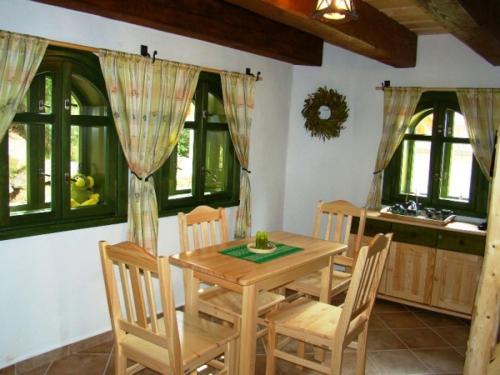 a dining room with a wooden table and chairs at Hotel Podlesí in Podlesí