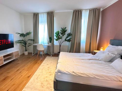 een slaapkamer met een bed en een flatscreen-tv bij Modernes City-Apartment in Möchengladbach in Mönchengladbach