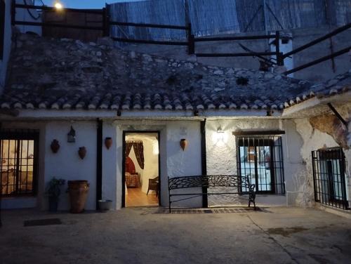 an entrance to a white house at night at Casa Rural Cueva El Sauce in Pegalajar