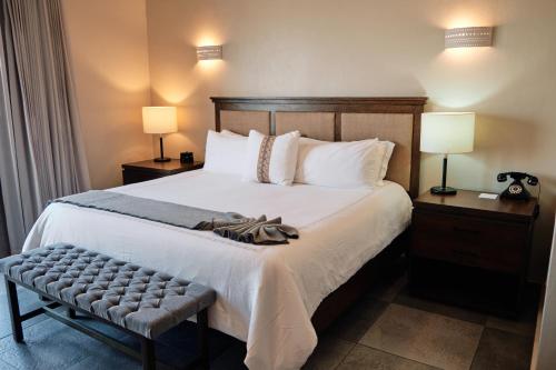 1 dormitorio con 1 cama grande con 2 lámparas y un banco en Casa Lucila Hotel Boutique en Mazatlán