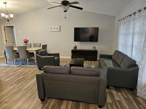 a living room with a couch and a flat screen tv at Seabreeze 3-Bedroom Pool Villa close to the beach!!! in Port Charlotte