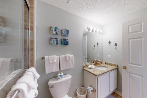 uma casa de banho com um WC, um lavatório e um espelho. em The Beach Club 1006D em Gulf Highlands