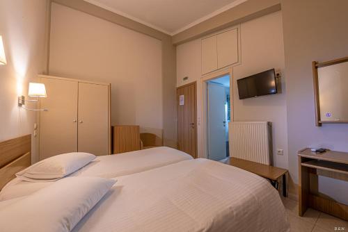 a hotel room with two beds and a television at Castella Beach in Alissos