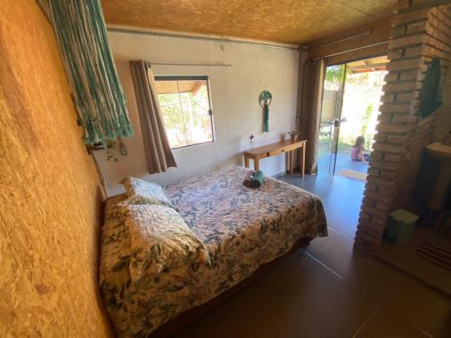 una camera con un letto in una stanza con una finestra di Casa Raízes Capão a Vale do Capao
