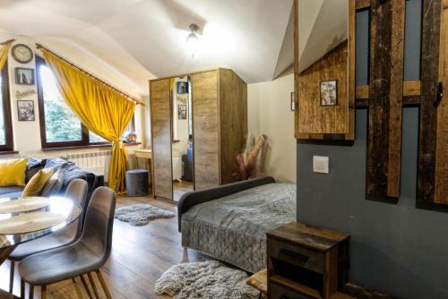 een slaapkamer met een bed, een bank en een tafel bij Borovets Dream Studio in Borovets
