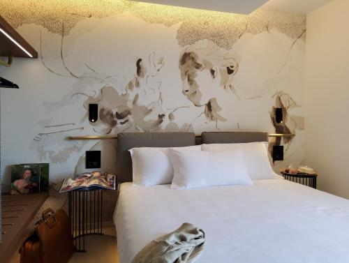 a bedroom with a bed and a wall with a mural at Panorama Hotel Friuli - Boutique Hotel in San Daniele del Friuli