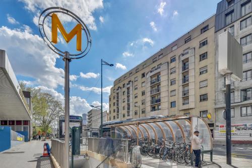 Un homme debout à côté d'un panneau m dans une rue dans l'établissement Le Cli’Chic, à Clichy