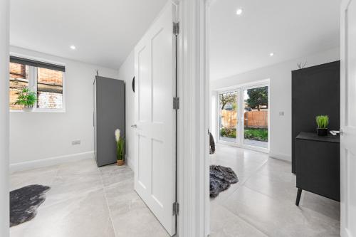 a living room with white walls and a door at SERCASA - Woodside Park - North Finchley in Whetstone