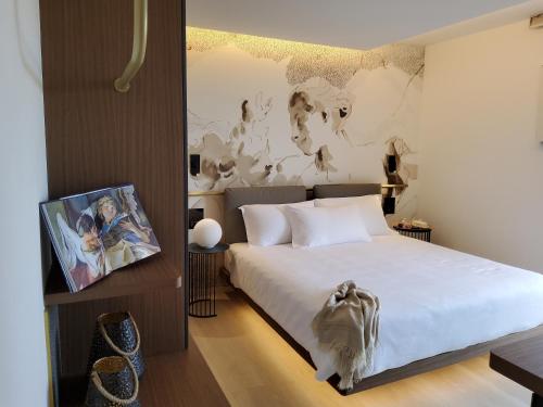 聖達涅萊德爾夫留利的住宿－Panorama Hotel Friuli - Boutique Hotel，卧室配有一张床,墙上挂有绘画作品