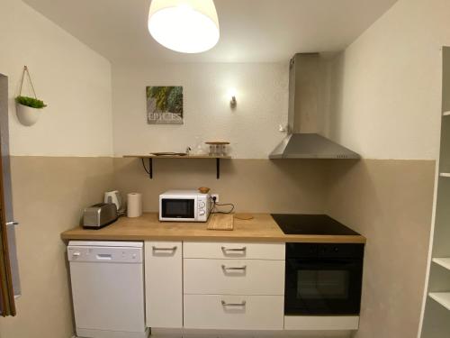 une cuisine avec un comptoir avec un micro-ondes dans l'établissement Au pied de la cité, T3 au calme, à Carcassonne