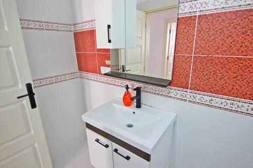 a bathroom with a white sink and a mirror at Ozkan Apartment - Fethiye Center Fully Furnished 50Mbps Wifi Netflix in Fethiye