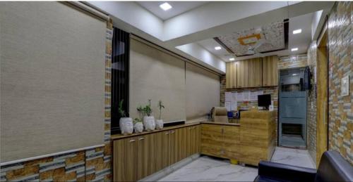 eine Küche mit Holzschränken und einem großen Bildschirm in der Unterkunft HOTEL GREENITY in Ahmedabad
