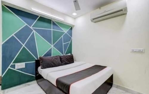 ein kleines Bett in einem Zimmer mit einer Wand in der Unterkunft HOTEL GREENITY in Ahmedabad