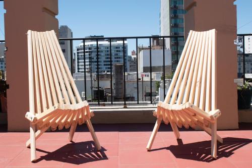dwa drewniane krzesła siedzące na dachu w obiekcie Habitaciones Temporarias CABA w BuenosAires