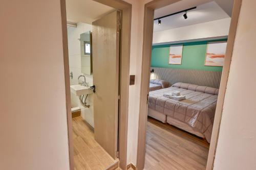 een slaapkamer met een bed en een wastafel in een kamer bij M383 Hotel Bariloche in Bariloche