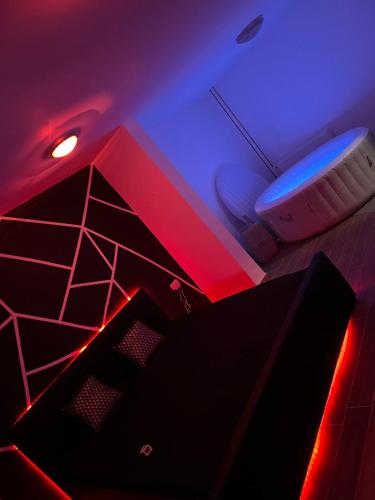 a room with red and blue lights and a tub at LUXSPAKR in Kranj