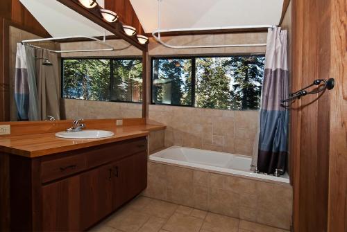 a bathroom with a tub and a sink and a shower at Alpine Darling- Hot Tub- Pet Friendly- 3 Minute Drive to Palisades Tahoe in Alpine Meadows