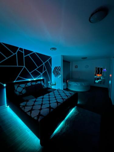 Cette chambre sombre dispose d'un lit avec des lumières bleues. dans l'établissement LUXSPAKR, à Kranj