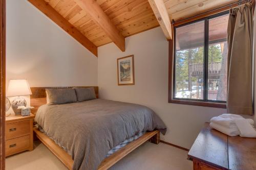 a bedroom with a bed and a window at Base Camp- Hot Tub, Large Deck, Wood Fireplace, Short Drive to Ski Resorts! in Tahoe City