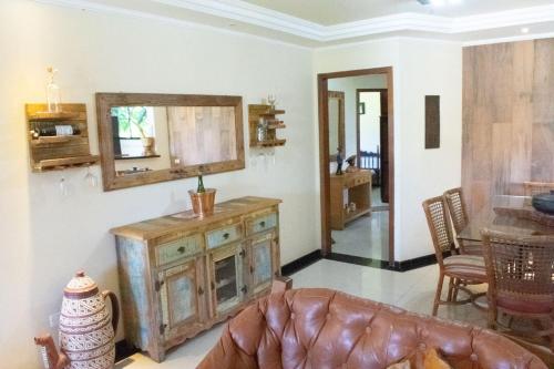 - un salon avec une armoire en bois et un miroir dans l'établissement Casa a 5 min do Balneario Coroados - Guaratuba PR, à Guaratuba