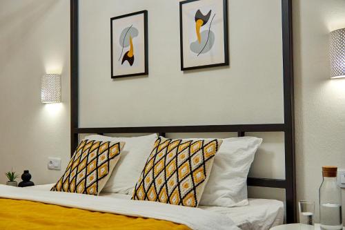 a bedroom with a bed with three pictures on the wall at Best Apartments on Kyryla & Mefodia in Mukacheve