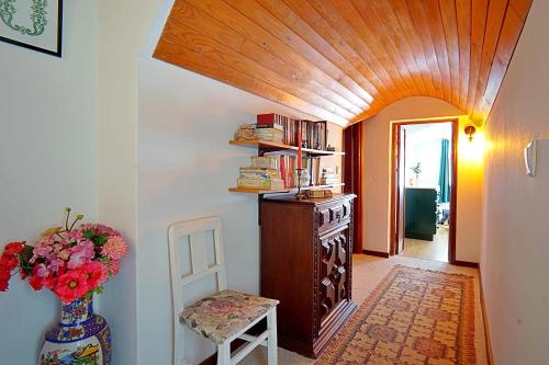 a hallway with a vase of flowers and a chair at Casa dos Plátanos near the center of Amarante, Golf Course and Water Park. in Amarante