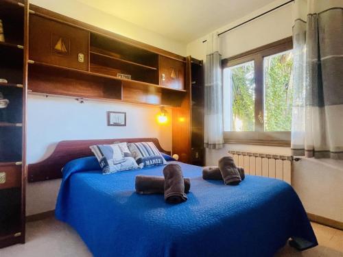 um quarto com 2 camas e lençóis azuis em Casa Gran em Calonge