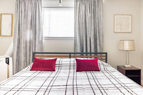 a bedroom with a bed with two red pillows at King & Queen First Floor Unit! 1-2c Georgetown Villas in Fairview Park