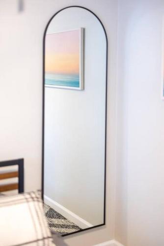 a mirror on a wall next to a bed at King & Queen First Floor Unit! 1-2c Georgetown Villas in Fairview Park