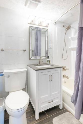 a white bathroom with a toilet and a sink at King & Queen First Floor Unit! 1-2c Georgetown Villas in Fairview Park