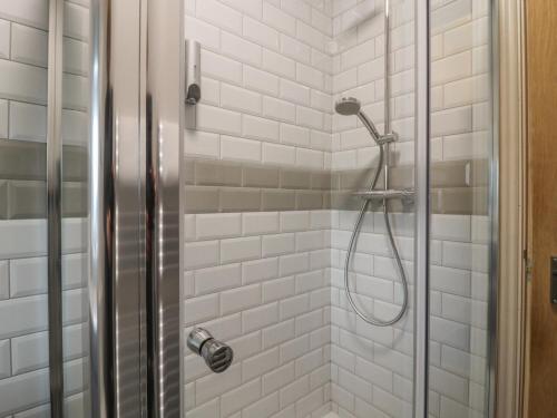 a bathroom with a shower with white tiles at Cononley Cottage in Keighley