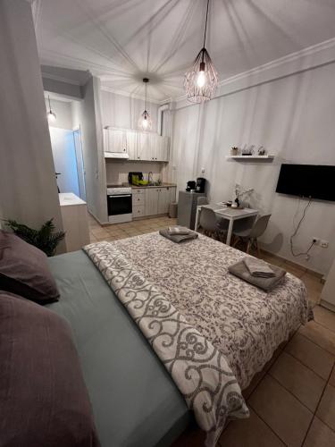 a large bed in a room with a kitchen at Nikoletta's home in Komotini
