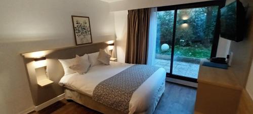 una camera d'albergo con letto e finestra di AMHotel Italie a Parigi