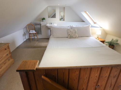 a bedroom with a large bed in a attic at Plas Bach in Rhoscolyn