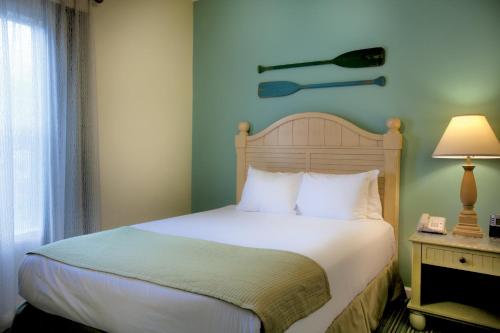 a bedroom with a bed and a lamp on a table at Club Wyndham Beach Street Cottages in Destin