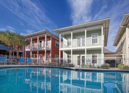 a building with a swimming pool in front of a building at Club Wyndham Beach Street Cottages in Destin