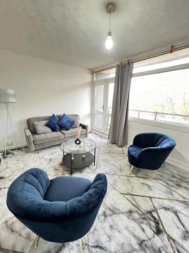 sala de estar con 2 sillas azules y sofá en Entire 3 Bedroom Luxury Apartment in London with Private Balcony en Londres